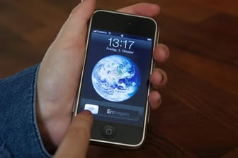 Eine Nutzerin entsperrt ein iPhone 2G mit der Schiebe-Geste, die Apple patentgeschützt hat: Samsung soll Apple 539 Millionen Dollar wegen Patentverletzungen zahlen.
