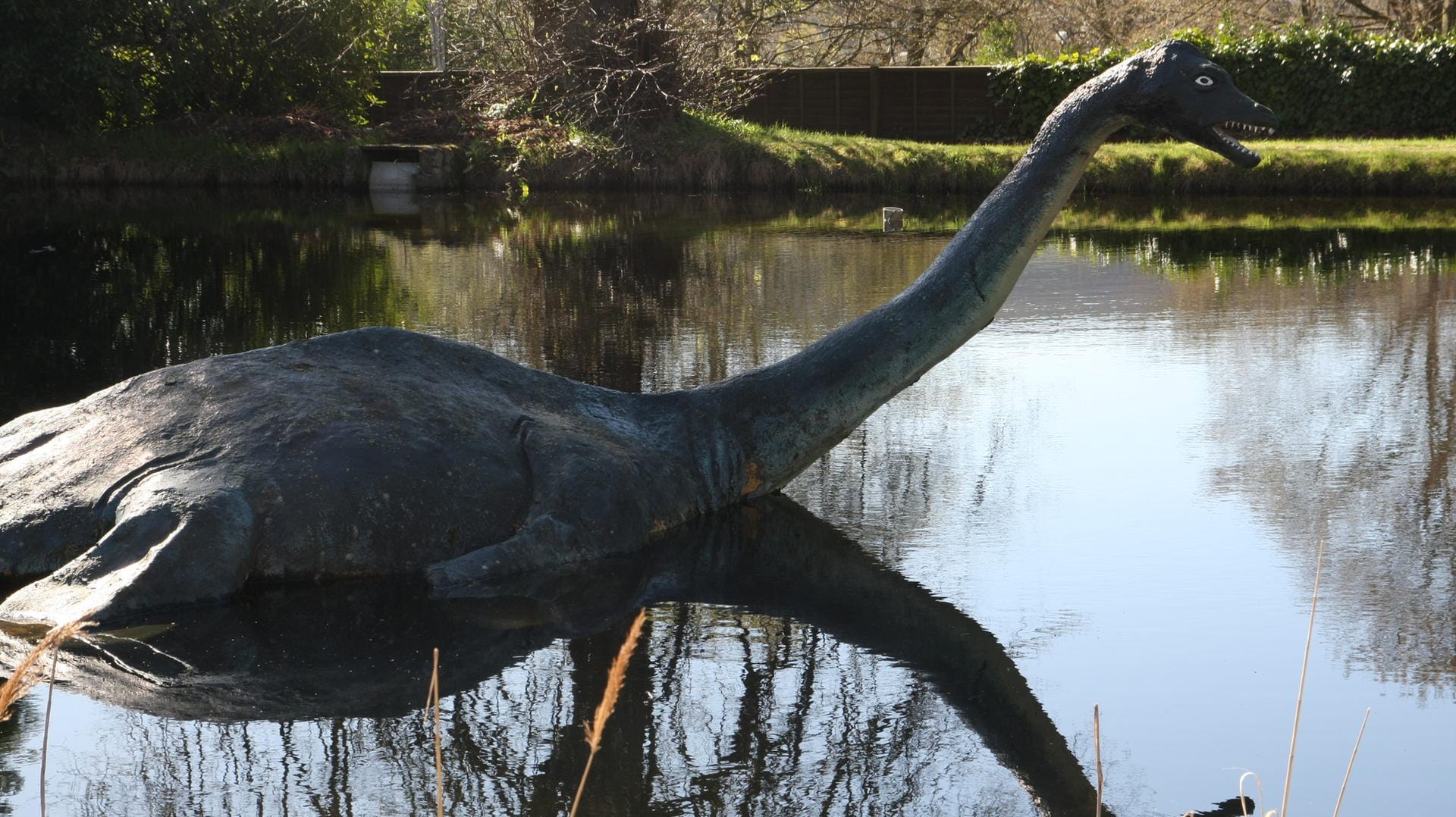 Eine Nessie-Figur im schottischen Hochland ragt aus dem Wasser