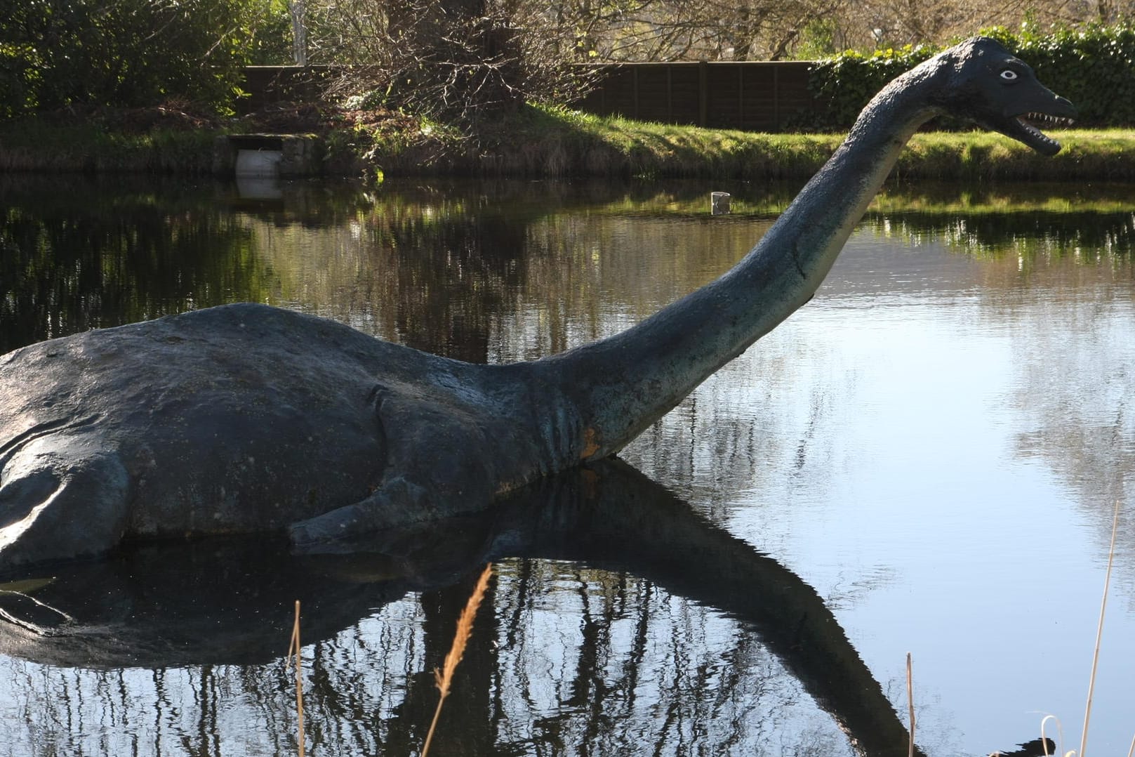 Eine Nessie-Figur im schottischen Hochland ragt aus dem Wasser