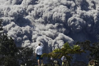 Ein Besucher im Volcano Country Club auf Hawaii fotografiert eine Aschewolke des Vulkans Kilauea.