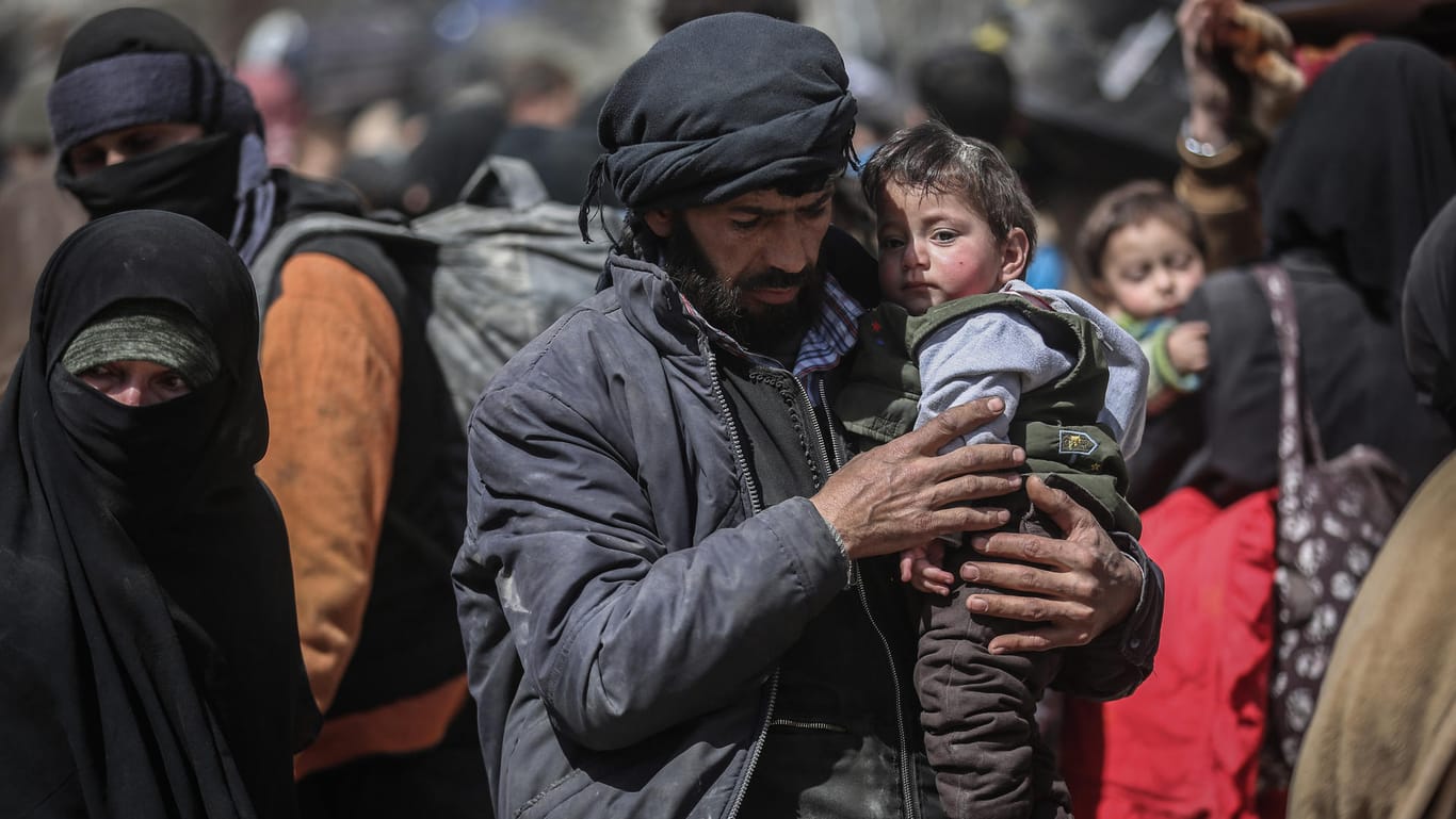 Ein Mann trägt ein kleines Kind auf dem Arm als sie aus der zerstörten Region Ost-Ghuta in Sicherheit gebracht werden: Unter Missbilligung westlicher Staaten übernimmt das Bürgerkriegsland Syrien am Montag den Vorsitz der Abrüstungskonferenz in Genf.