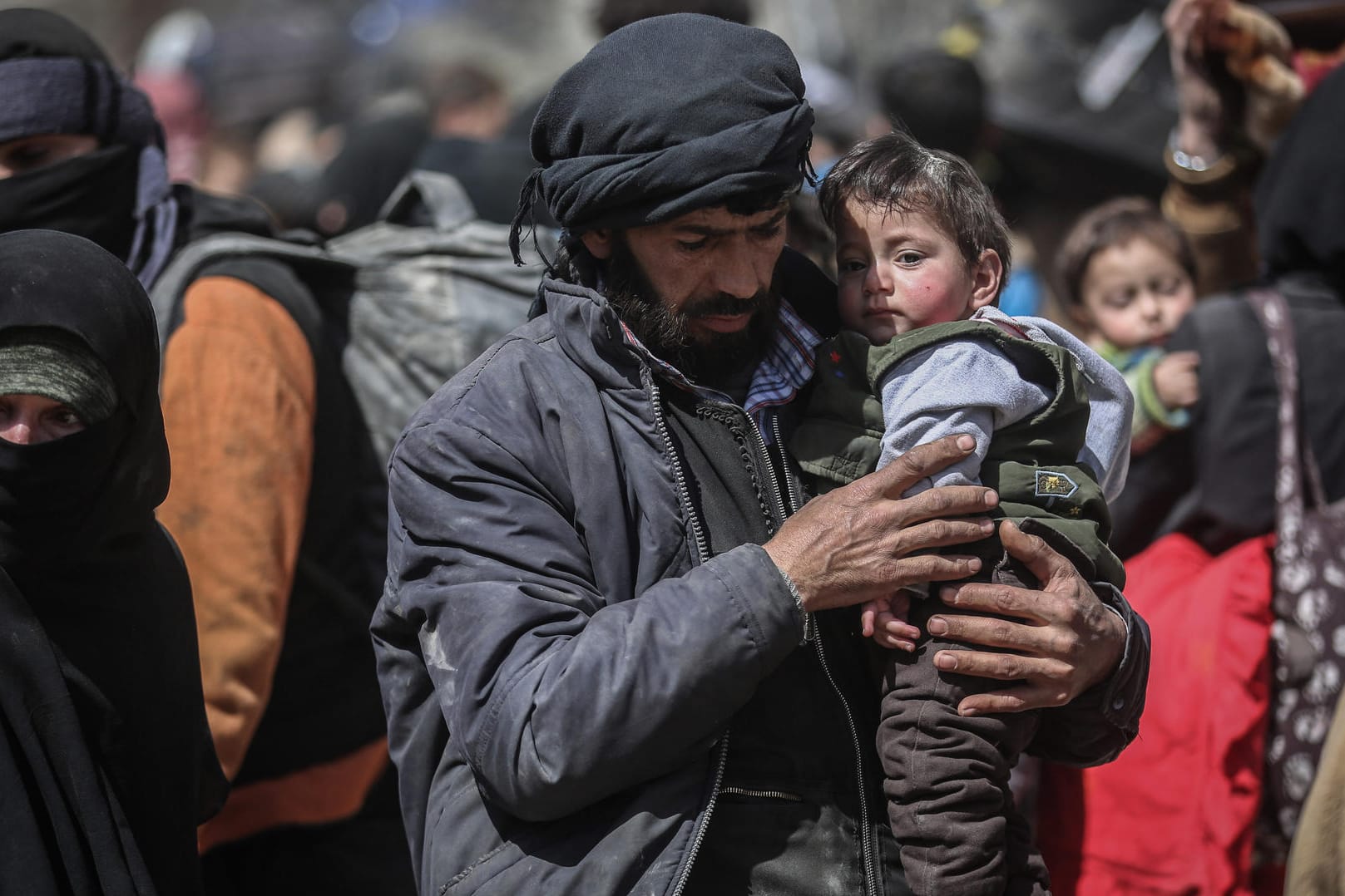Ein Mann trägt ein kleines Kind auf dem Arm als sie aus der zerstörten Region Ost-Ghuta in Sicherheit gebracht werden: Unter Missbilligung westlicher Staaten übernimmt das Bürgerkriegsland Syrien am Montag den Vorsitz der Abrüstungskonferenz in Genf.