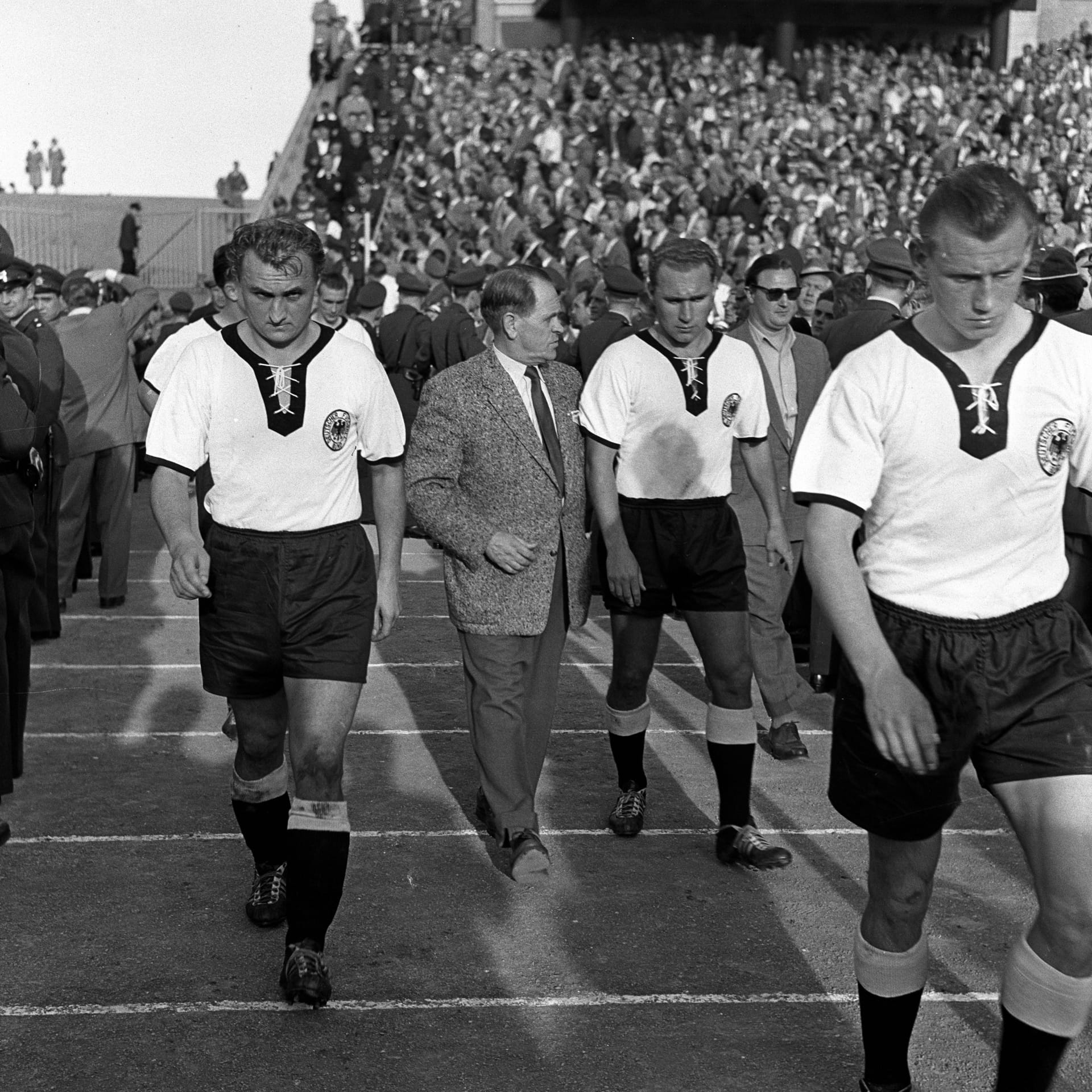 Uli Biesinger (rechts) läuft für das deutsche Nationalteam ein: Der Spieler durfte 1954 ohne Länderspiel-Erfahrung mit zur WM in der Schweiz.