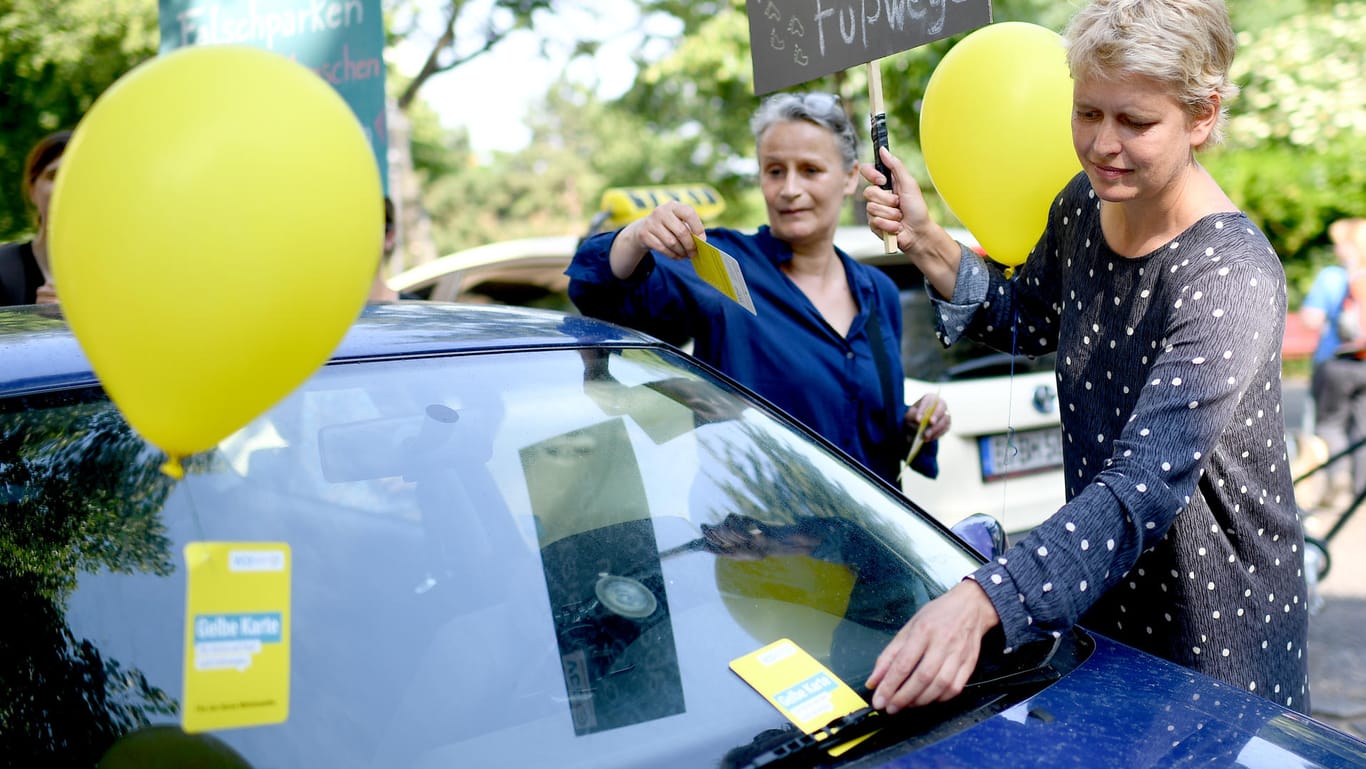 Aktivistinnen in Berlin heften einem Auto, das auf einem Fußgängerübergang geparkt wurde, eine "Gelbe Karte" an: Der Verkehrsclub Deutschland VCD und die Initiative Clevere Städte kennzeichnen zur bundesweiten Falschparker-Woche Autos, die nicht ordnungsmäßig geparkt wurden.