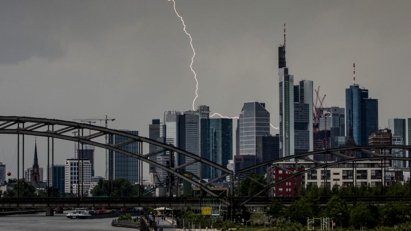 Frankfurt am Main: Ein Blitz durchzuckt den Abendhimmel während eines Gewitters über den Frankfurter Bankentürmen.
