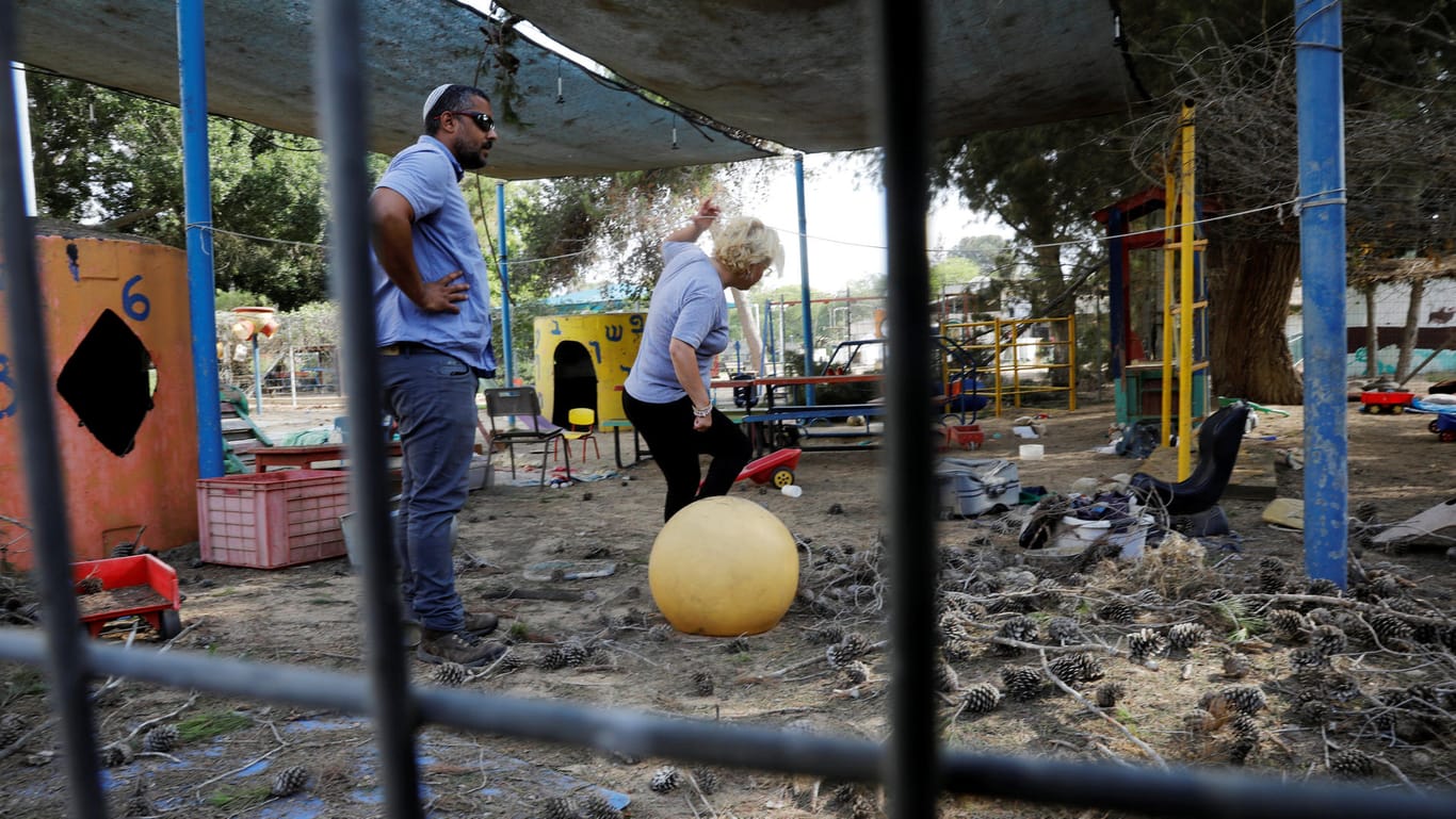 Menschen stehen im Hof eines Kindergartens: Militante Palästinenser feuern Mörsergranaten auf Israel und verfehlen nur knapp einen Kindergarten.