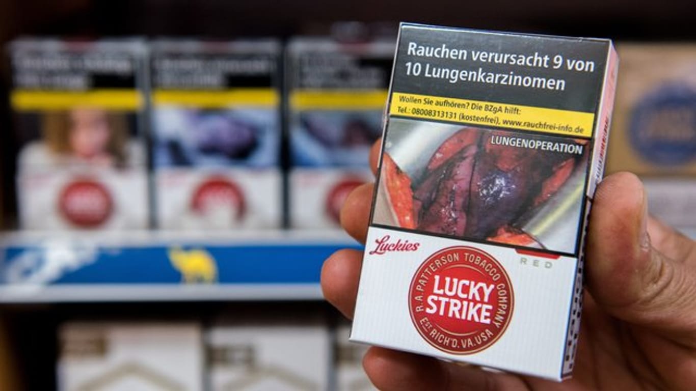 Zigarettenschachtel mit Schockfoto einer Lungenoperation und Warnhinweis.