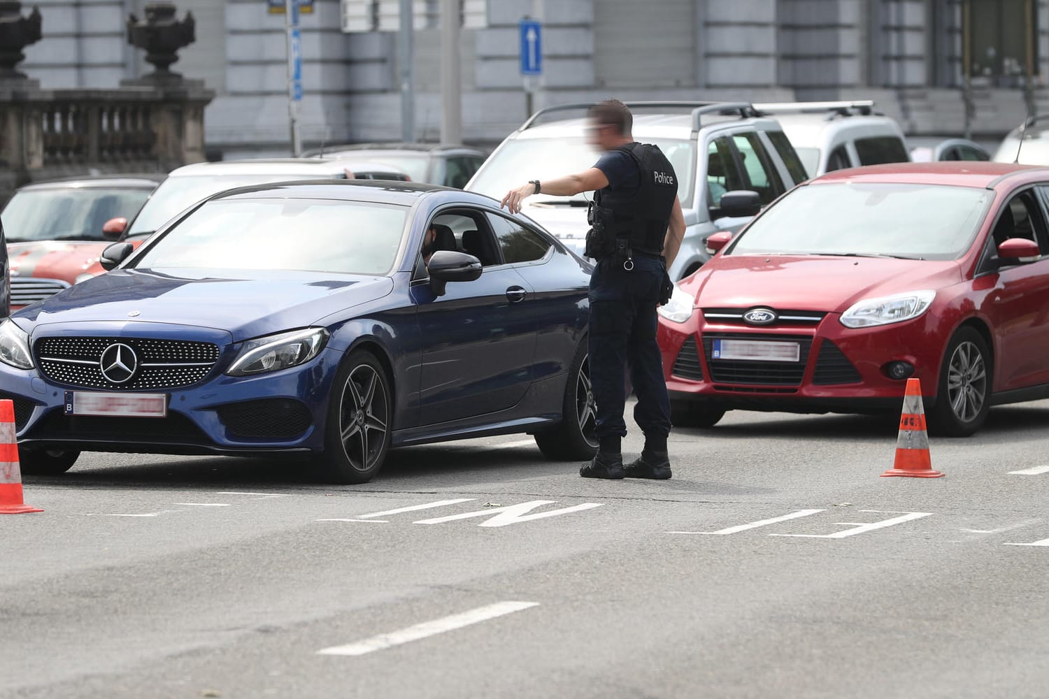 Lüttich: Polizisten leiten den Verkehr um, nachdem in der Nähe bei einer Geiselnahme Schüsse gefallen sind. Bei der Geiselnahme sind drei Menschen gestorben, darunter auch zwei Polizisten.