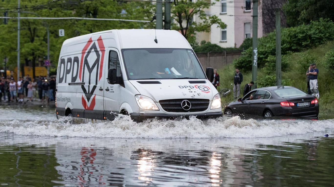 Duisburg: Ein Lieferdienst fährt durch eine überfluteten Straße.