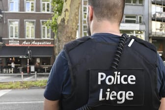 Ein Polizist schaut in Richtung des Tatorts der Geiselnahme: Ein Terrorverdächtiger hat am Dienstag in Lüttich drei Menschen getötet und eine Frau als Geisel genommen.