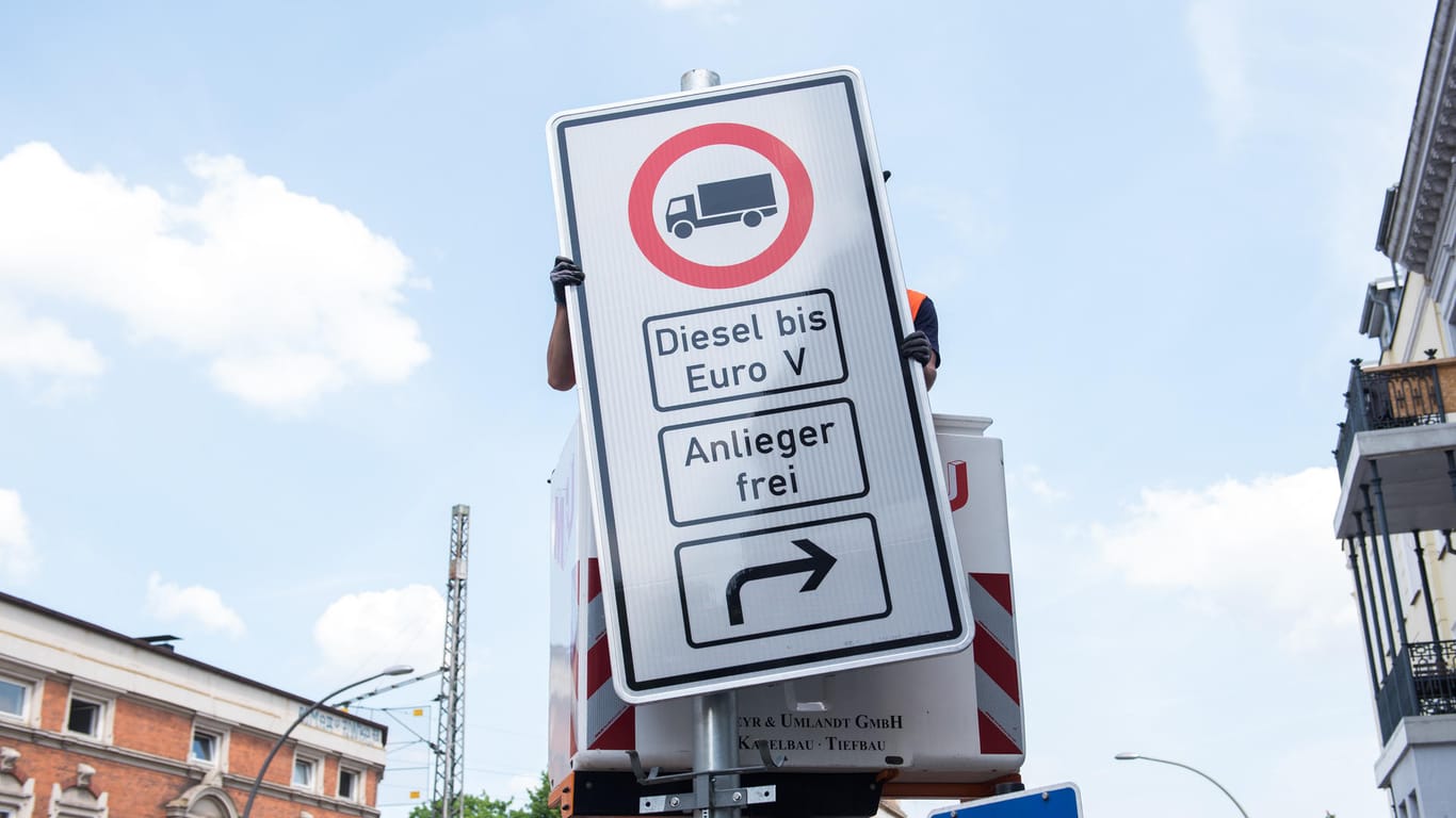 Aufbau eines Fahrverbotsschilds: Hamburg sperrt als erste Stadt besonders schmutzige Dieselautos und -Lkw auf einigen Strecken aus.
