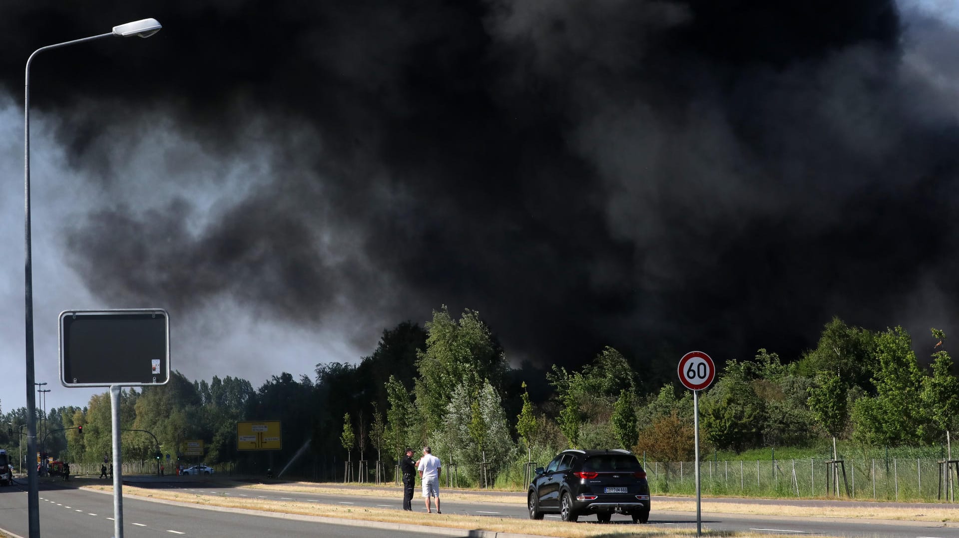 Eine tiefe Rauchwolke zieht über eine Straße in Rostock.