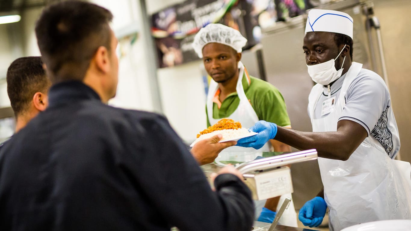 Zwei Flüchtlinge arbeiten an einer Essensausgabe: Rund 1,7 Millionen Menschen kamen zwischen 2015 und 2017 nach Deutschland.