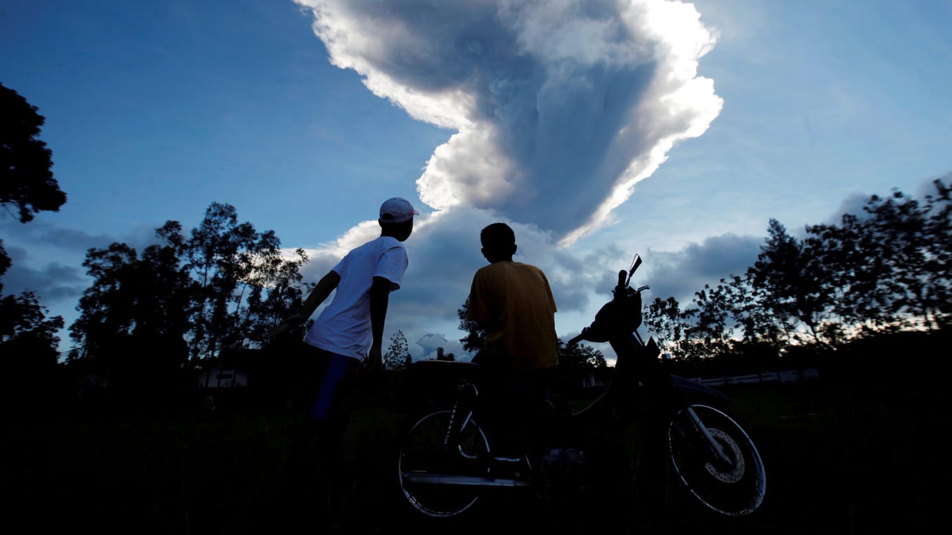 Menschen beobachten den Ausbruch des Merapi von einem Dorf in der Nähe von Yogyakarta aus: 2010 starben 300 Personen bei einer Erosion des Vulkans.