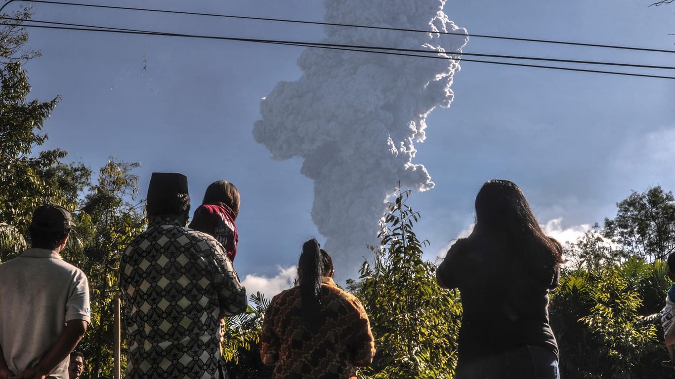 Anwohner beobachten den Asche spuckenden Vulkan Merapi.