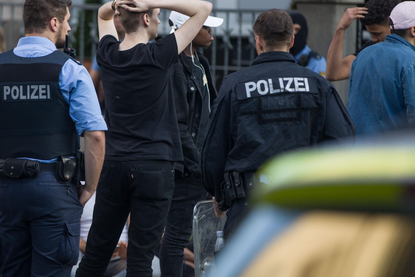Polizisten bewachen am frühen Morgen eine Gruppe festgesetzter junger Männer: In der Nacht war es nach einem Musikfestival in Darmstadt zu Ausschreitungen gekommen.