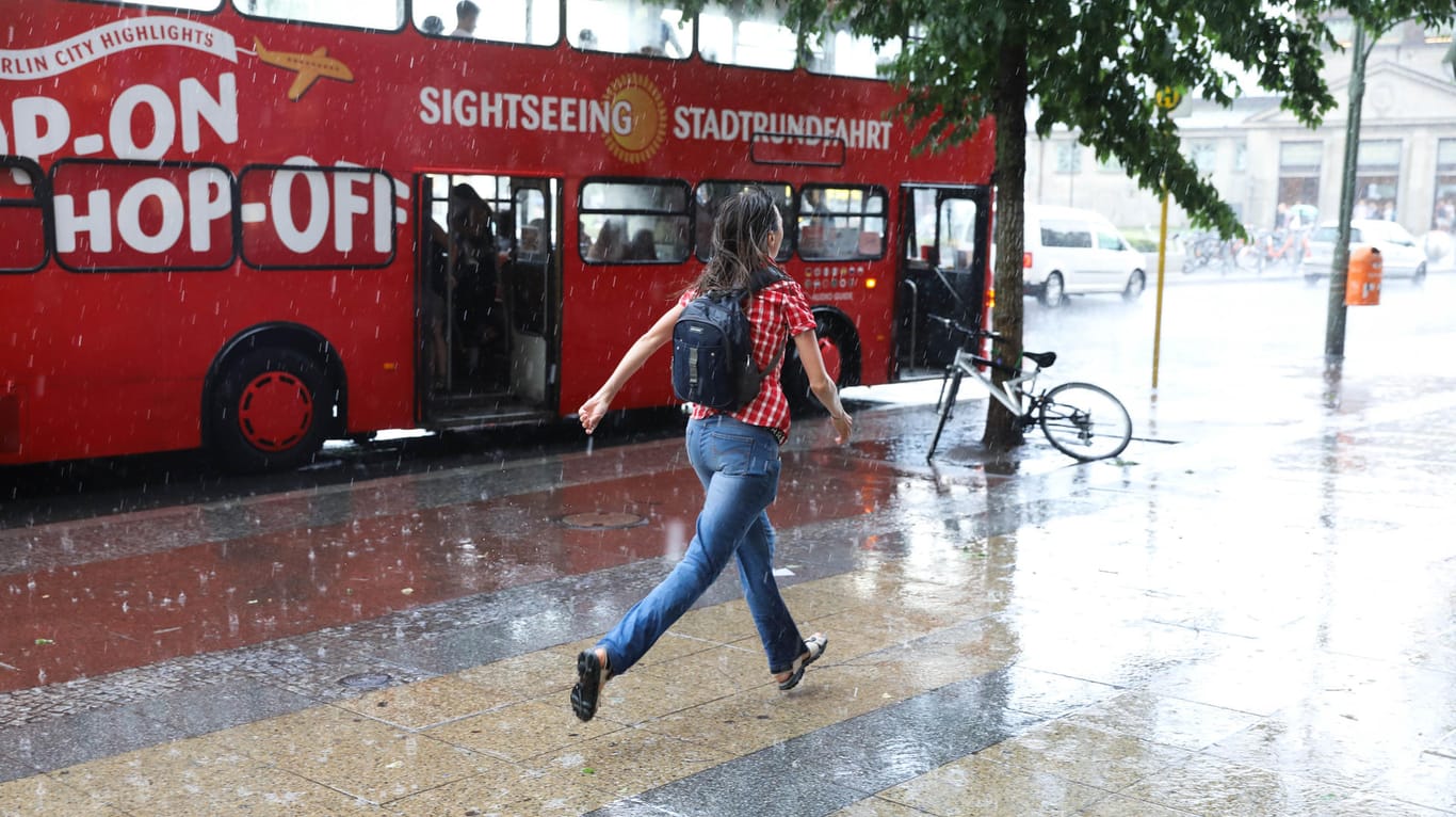 Eine Frau läuft durch den Regen in Berlin (Archiv)