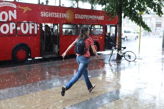 Eine Frau läuft durch den Regen in Berlin (Archiv)