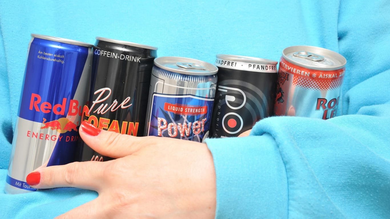 Eine Frau trägt diverse Energie-Drinks: Eine SPD-Politikerin will die Coffein-Bomben für Kinder verbieten.