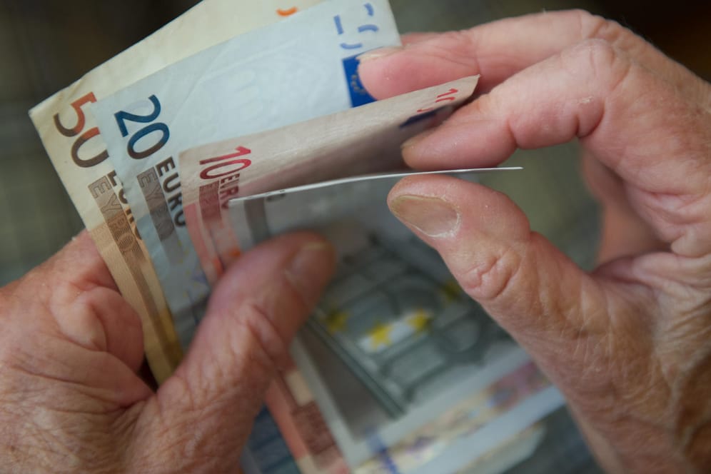 Eine ältere Frau zählt Geld: Die meisten Deutschen rechnen damit, dass es für sie im Alter finanziell eng wird.