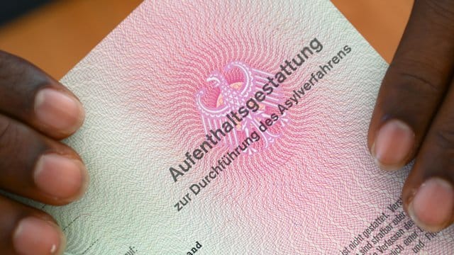 Er hat es geschafft: Ein somalischer Flüchtling hält eine Aufenthaltsgestattung in den Händen. Er hat es geschafft: Ein somalischer Flüchtling hält eine Aufenthaltsgestattung in den Händen.