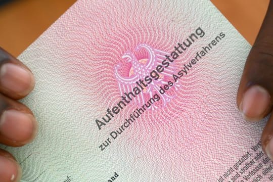 Er hat es geschafft: Ein somalischer Flüchtling hält eine Aufenthaltsgestattung in den Händen.