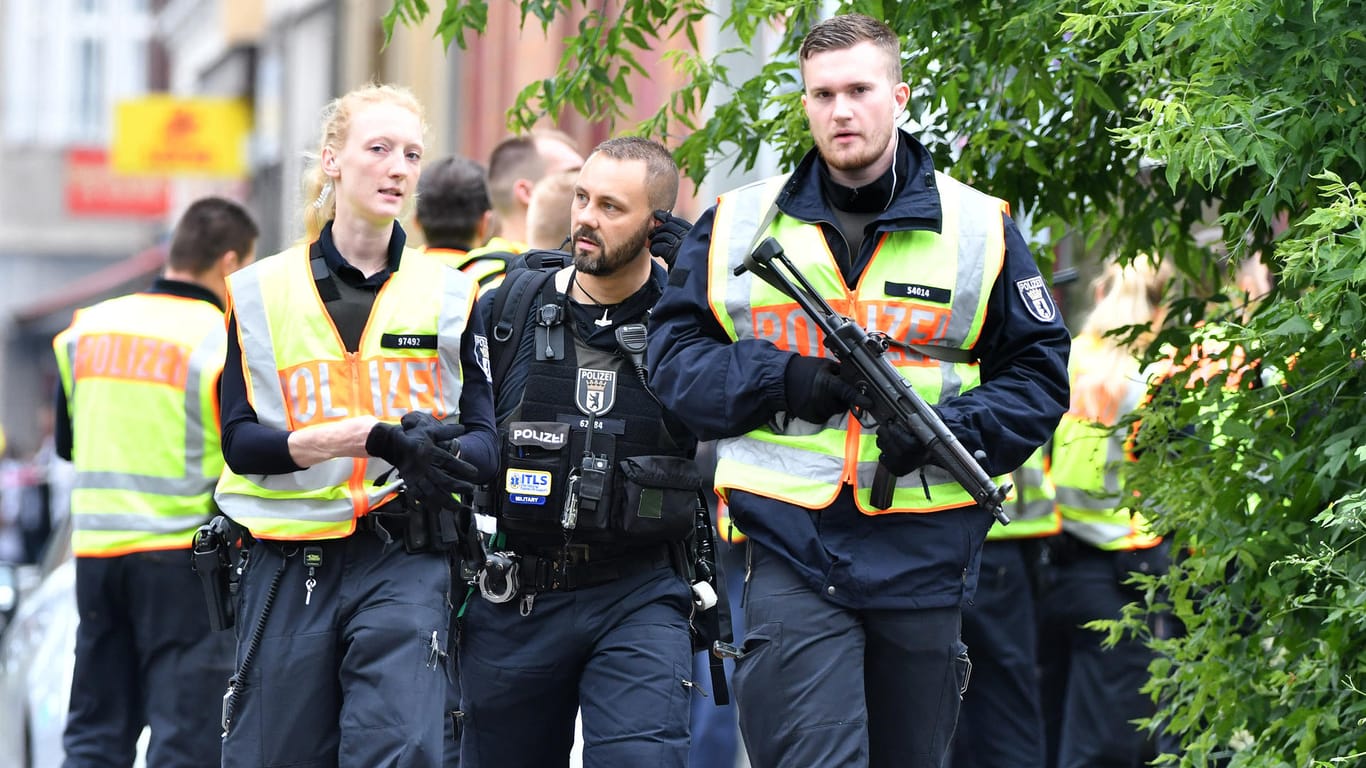 Polizisten stehen mit Waffen und Warnwesten vor einer Berliner Grundschule: An einer Berliner Grundschule in Gesundbrunnen im Bezirk Mitte hat es einen Polizeieinsatz gegeben. Es gehe um den "Verdacht einer Gefahrenlage".