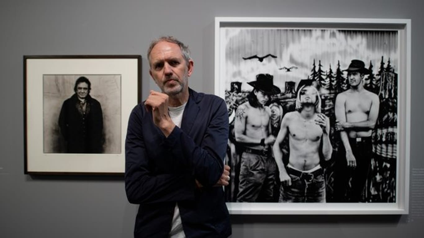 Der niederländische Fotograf Anton Corbijn im Bucerius Kunst Forum vor seinen Fotografien der Band Nirvana (1993, r) und dem Country-Star Johnny Cash (1993).
