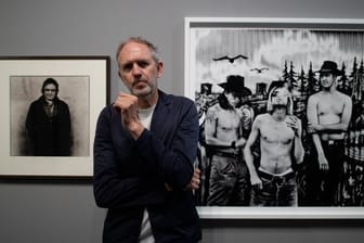 Der niederländische Fotograf Anton Corbijn im Bucerius Kunst Forum vor seinen Fotografien der Band Nirvana (1993, r) und dem Country-Star Johnny Cash (1993).