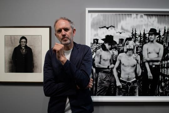 Der niederländische Fotograf Anton Corbijn im Bucerius Kunst Forum vor seinen Fotografien der Band Nirvana (1993, r) und dem Country-Star Johnny Cash (1993).