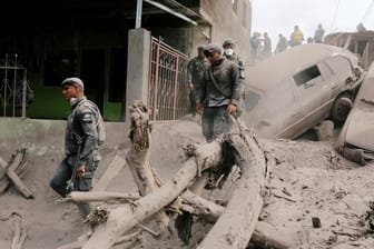 Policemen inspect at an area affected by the eruption of the Fuego volcano in the community of San Miguel Los Lotes in Escuintla