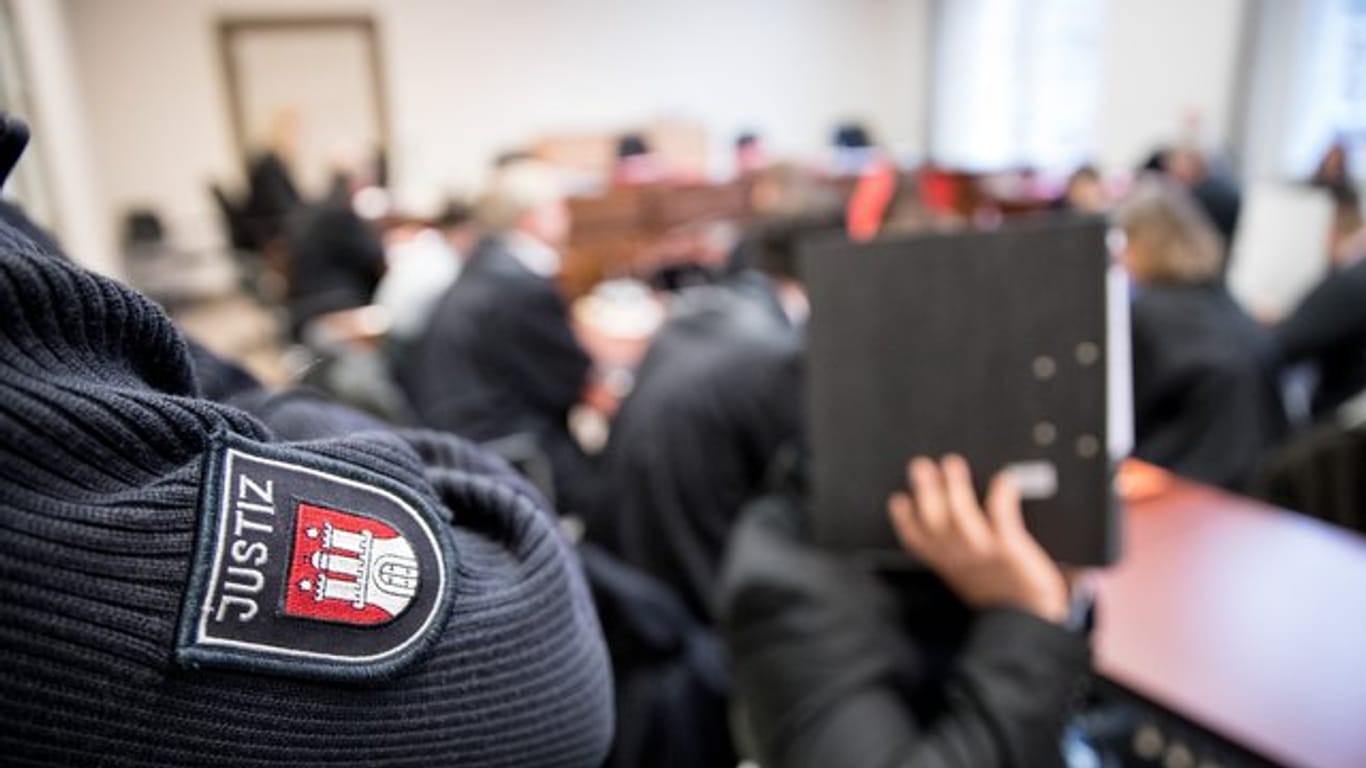 Die Angeklagten, ihre gesetzlichen Vertreter und Anwälte im Gerichtssaal in Hamburg.