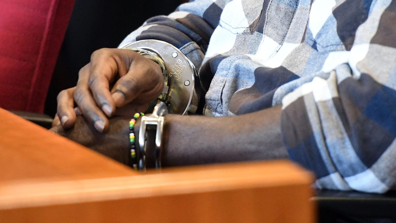 Bonn: Der Angeklagte trägt vor der Urteilsverkündung im Prozess wegen der Vergewaltigung einer Camperin im Landgericht Handschellen.