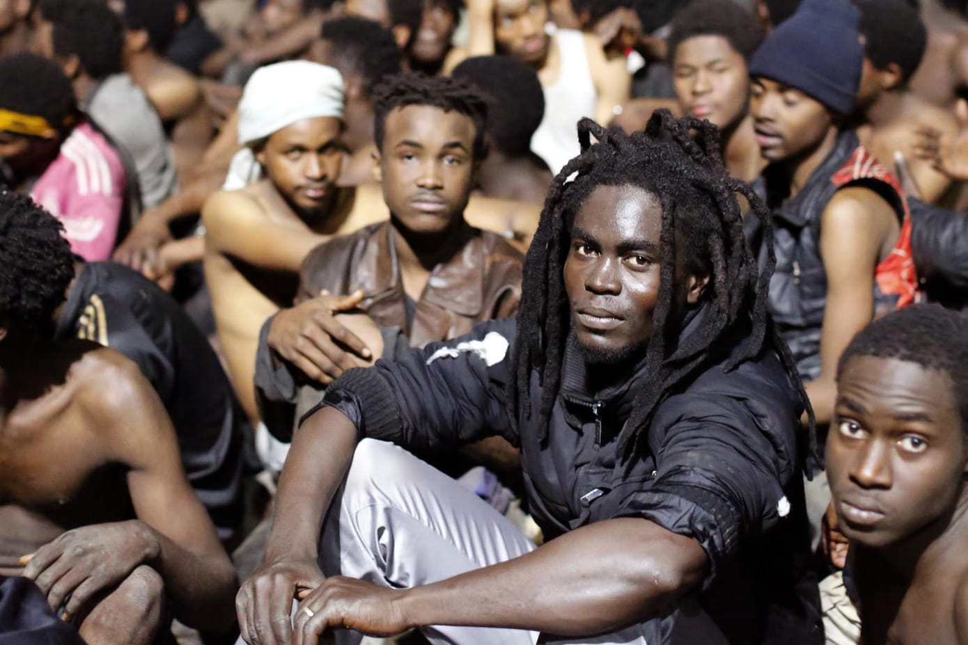 Migranten sitzen auf dem Boden, nachdem sie den Grenzzaun gestürmt haben: Zuletzt war es im Dezember 2017 zu einem Massenansturm gekommen. (Archivbild)