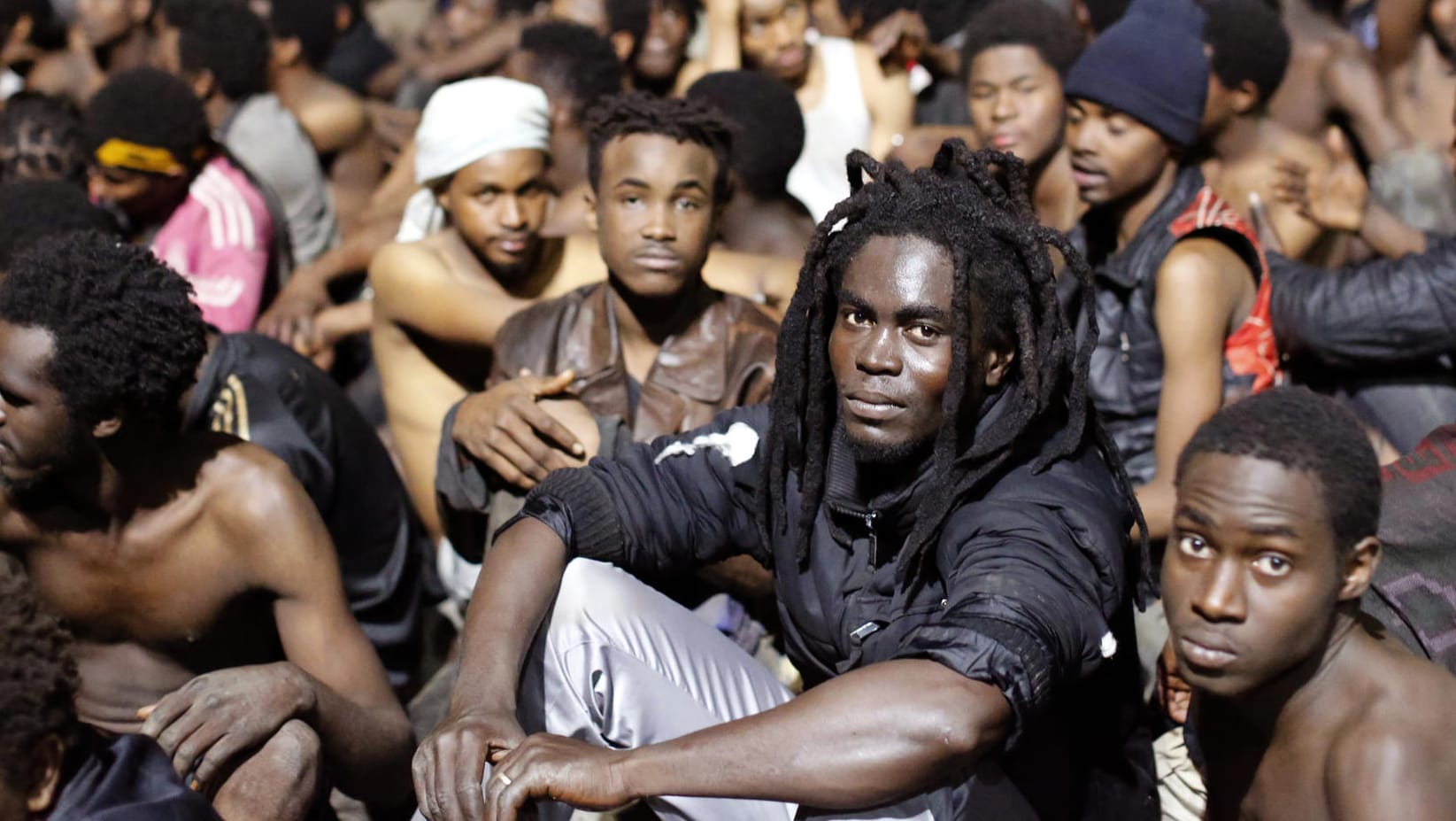 Migranten sitzen auf dem Boden, nachdem sie den Grenzzaun gestürmt haben: Zuletzt war es im Dezember 2017 zu einem Massenansturm gekommen. (Archivbild) Migranten sitzen auf dem Boden, nachdem sie den Grenzzaun gestürmt haben: Zuletzt war es im Dezember 2017 zu einem Massenansturm gekommen. (Archivbild)