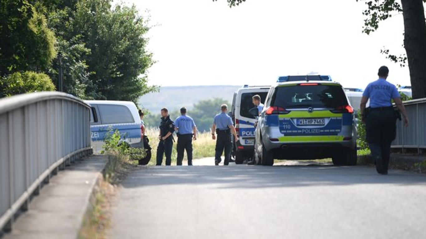 Polizisten warten an einem gesperrten Feldweg im Stadtteil Erbenheim.
