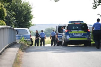 Polizisten warten an einem gesperrten Feldweg im Stadtteil Erbenheim.