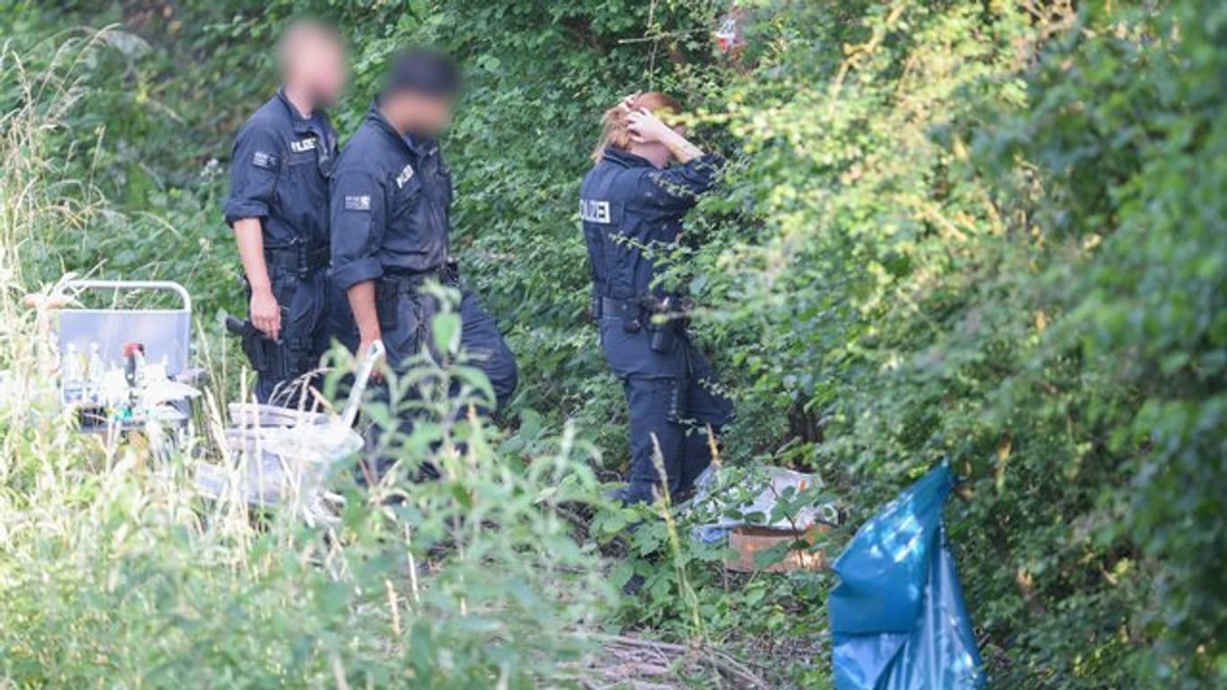 Polizisten am Leichenfundort in einem Gebüsch nahe Wiesbaden-Erbenheim.