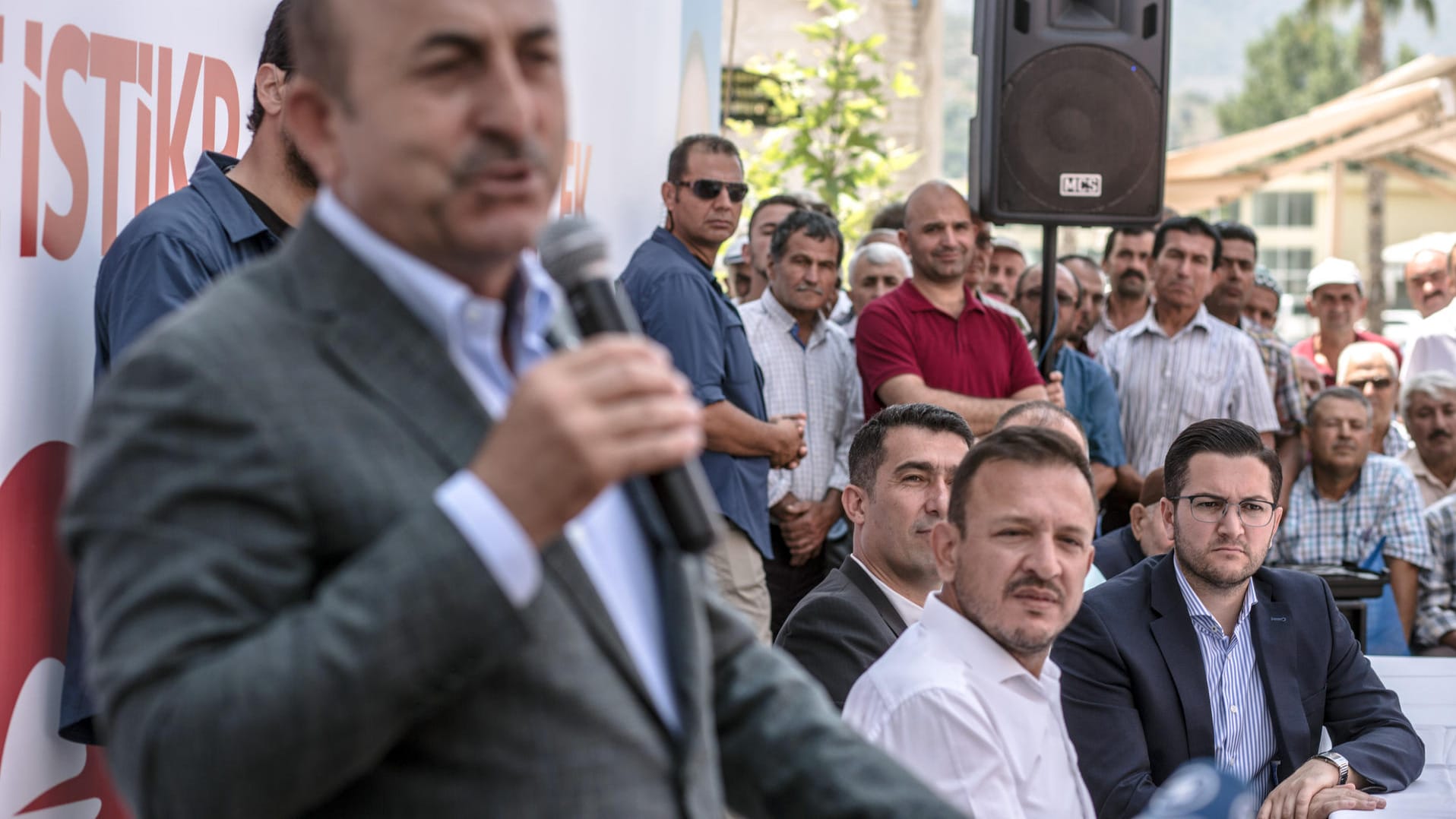 Mustafa Erkan bei einer Rede von Außenminister Mevlüt Cavusoglu: Der AKP-Politiker lobt Erkan für seine Bemühungen, die deutsch-türkischen Beziehungen verbessern zu wollen.