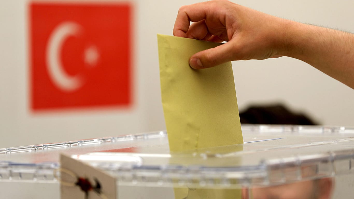 Ein Wähler wirft seinen Stimmzettel in eine Urne: Von heute an können Türken in Deutschland über Präsident und Parlament in der Türkei abstimmen.