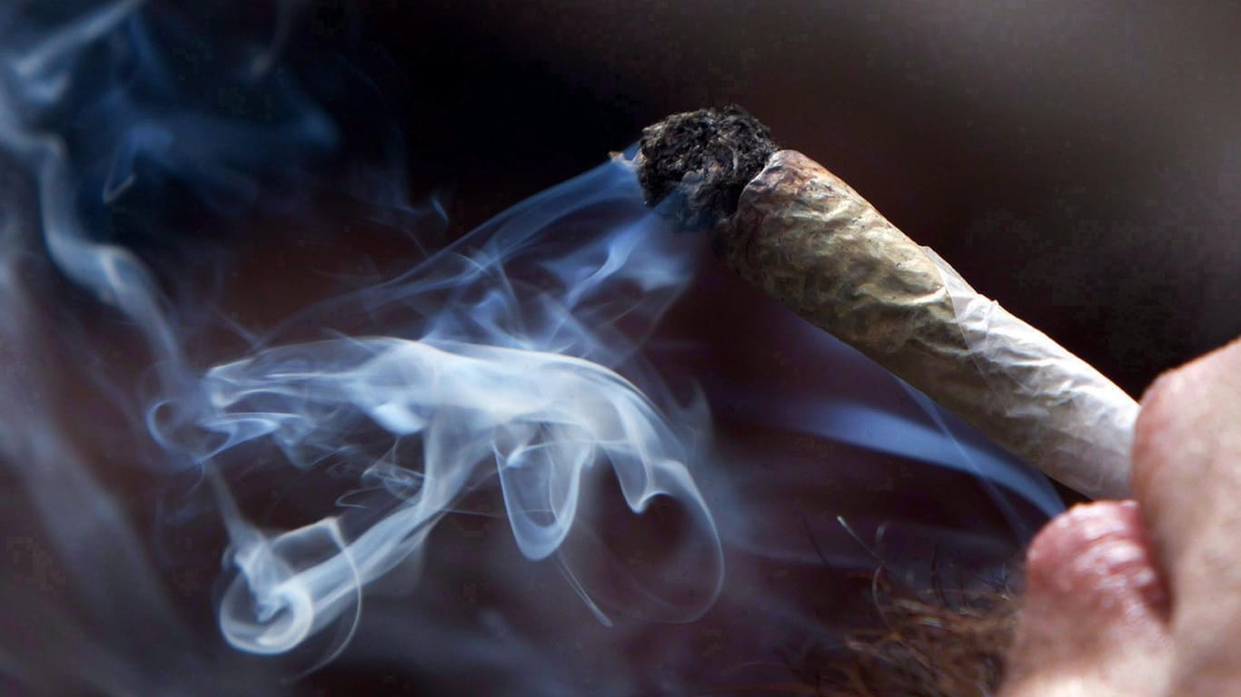 Ein junger Mann raucht einen Joint: In Deutschland soll bald bundesweit der Besitz von bis zu sechs Gramm straffrei bleiben.