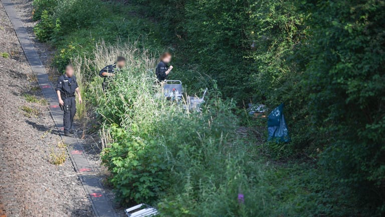 Polizeibeamte gehen an einer Bahnstrecke nahe Wiesbaden-Erbenheim entlang auf dem Weg zu einem Leichenfundort in einem Gebüsch: Susannas Mutter erhielt am Abend des Verschwindens eine Nachricht von Susannas Handy.