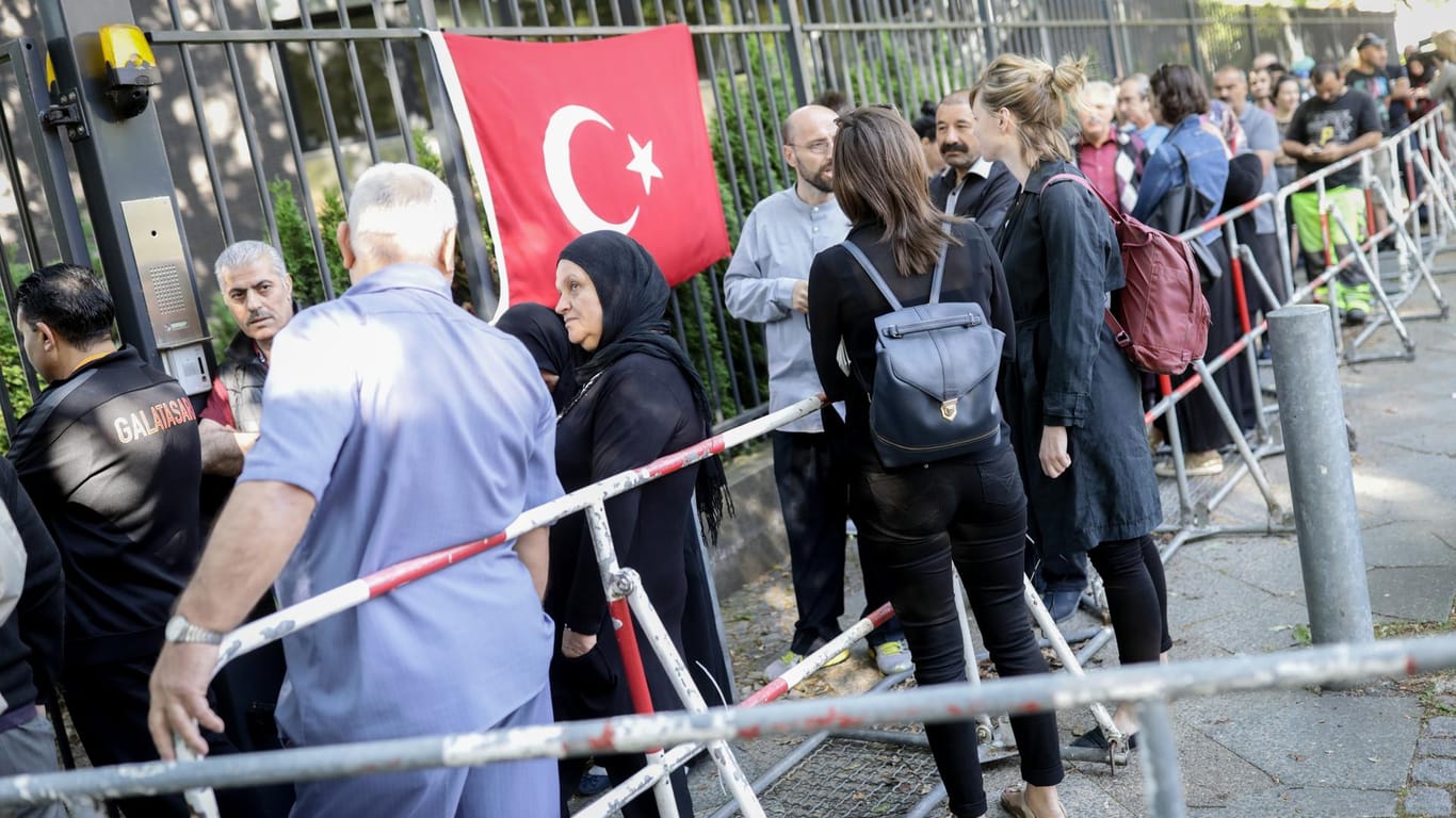 Wahlberechtigte stehen in einer Schlange vor dem Gelände des türkischen Generalkonsulats für die Stimmabgabe: Hier geben in Deutschland lebende Türken ihre Stimme für die türkischen Parlaments- und Präsidentenwahlen ab.