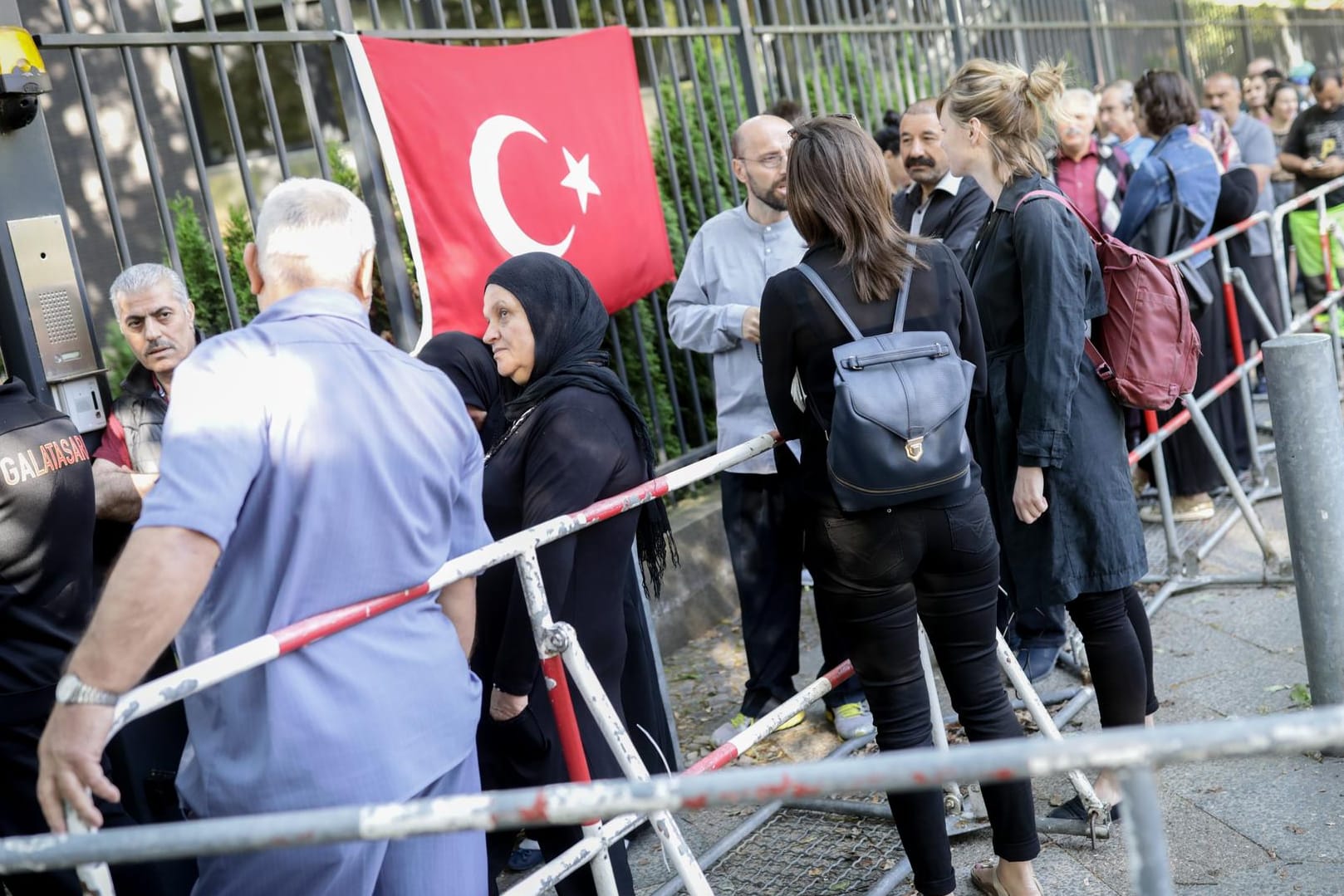 Wahlberechtigte stehen in einer Schlange vor dem Gelände des türkischen Generalkonsulats für die Stimmabgabe: Hier geben in Deutschland lebende Türken ihre Stimme für die türkischen Parlaments- und Präsidentenwahlen ab.