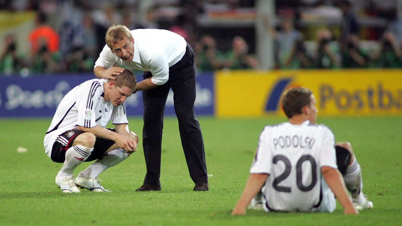 Das Ende des Sommermärchens: Bundestrainer Jürgen Klinsmann tröstet Bastian Schweinsteiger und Lukas Podolski nach der bitteren Halbfinal-Niederlage gegen Italien in der Verlängerung.