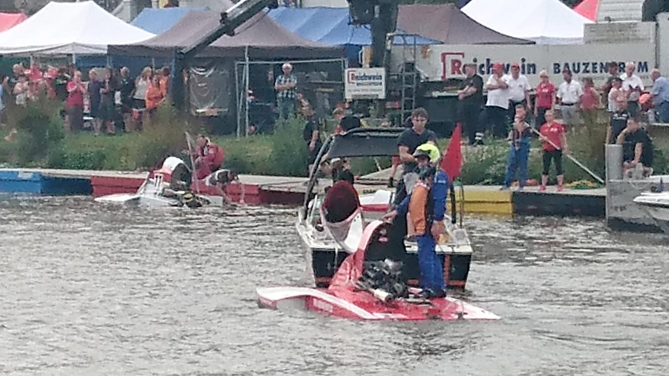 Rettungskräfte ziehen ein Boot aus dem Wasser: Der Veranstalter hat laut Polizei alle Rennen für das Wochenende abgesagt.