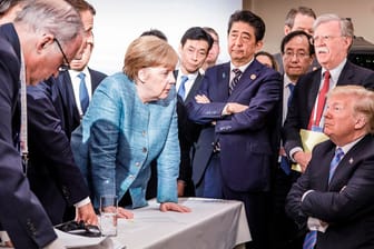 Sinnbild für die Stimmung beim G7-Gipfel: Kanzlerin Merkel mit weiteren Staats- und Regierungschefs, rechts US-Präsident in trotziger Pose.
