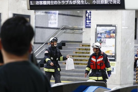 Feuerwehrleute gehen durch den Bahnhof in Odawara.