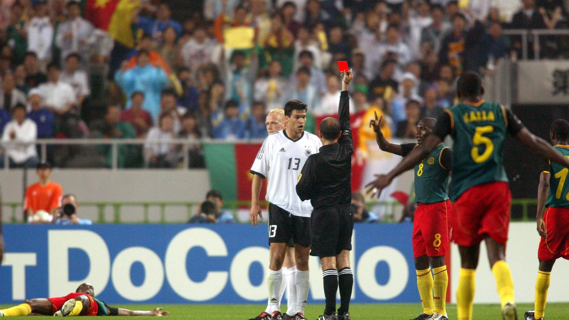 Carsten Ramelow versteckt sich hinter Michael Ballack, kann aber auch so dem Platzverweis von Schiedsrichter Antonio Lopez Nieto aufgrund des Fouls an Samuel Eto'o (l.) nicht entgehen.