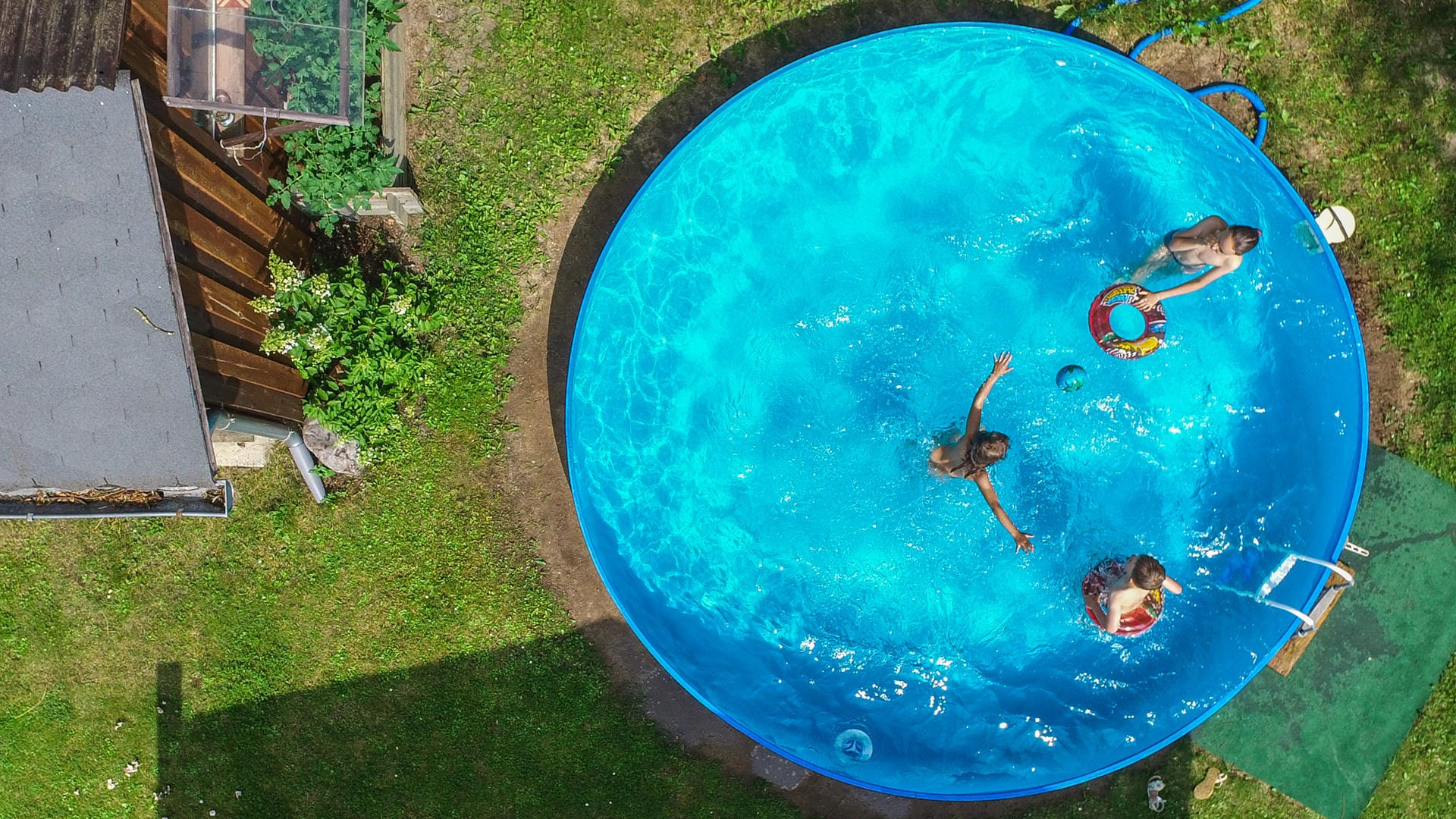 Kinder planschen in einem Garten im Pool: Im Planschbecken befinden sich oft auch Bakterien.